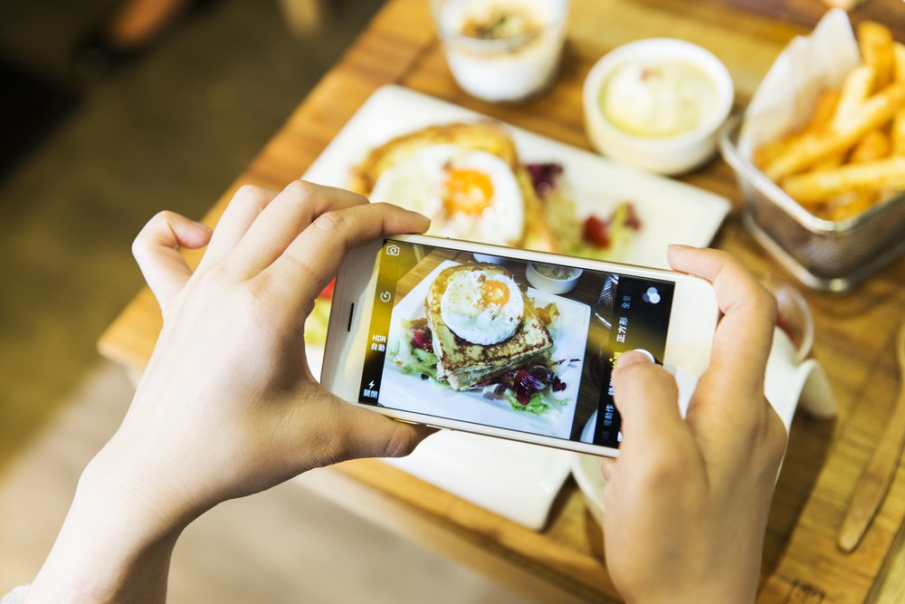 A person using their phone to take a photo of their meal