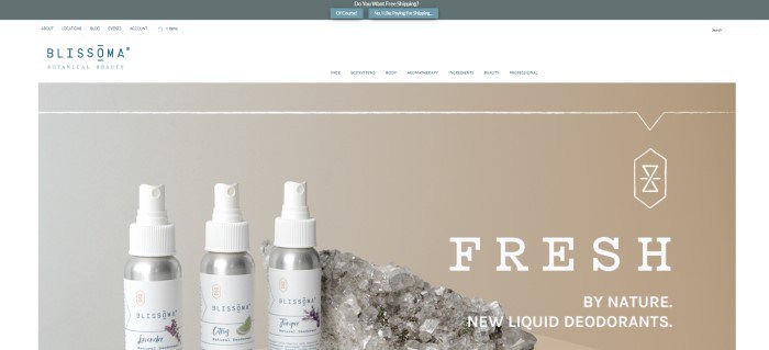 This screenshot of the home page for Blissoma Botanical Beauty shows a gray header announcing free shipping, a white navigation bar, and a large photo with a tan background and a row of three Blissoma liquid deodorants with white lids and white labels next to a large chunk of clear crystals.