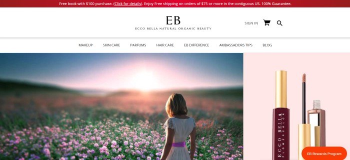 This screenshot of the home page for Ecco Bella has a red header and white navigation bar above a photo of a blonde girl in a white dress and lavender sash walking through a field of pink flowers at sunset, next to a product image of an Ecco Bella lip color.