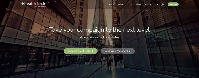 This screenshot of the home page for Health Trader has a dark filtered photo of a cityscape with tall buildings behind white text that reads "Take your campaign to the next level."
