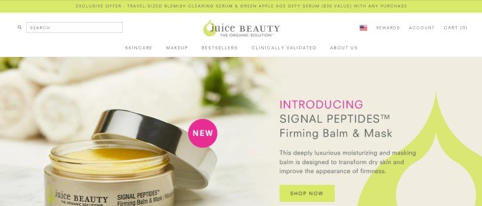 This screenshot of the home page for Juice Beauty has a light green header, white navigation bar and search bar, and a large photo of an open jar of a Juice Beauty firming mask next to three rolled white towels and text in black and pink describing the product.