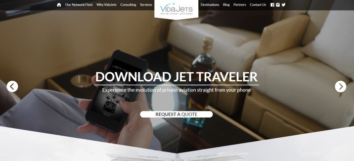 This screenshot of the home page for VidaJets has a black navigation bar above a filtered photo of the inside of a jet, which includes what appears to be white leather seats, a bottle of wine, and a man's hand holding a mobile phone, behind white text inviting people to download the Jet Traveler app.