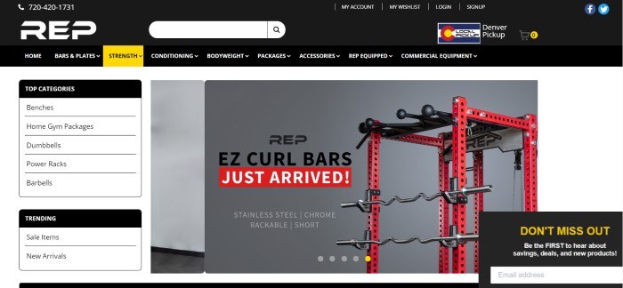 This screenshot of the home page for REP fitness has a black header with white lettering in the navigation bar, a yellow highlighted tab for strength training, a white and black section on the left side of the page for navigating through top categories and trending sales, and a photo on the right side of the page showing a black and red curl bar gym against a gray backdrop.