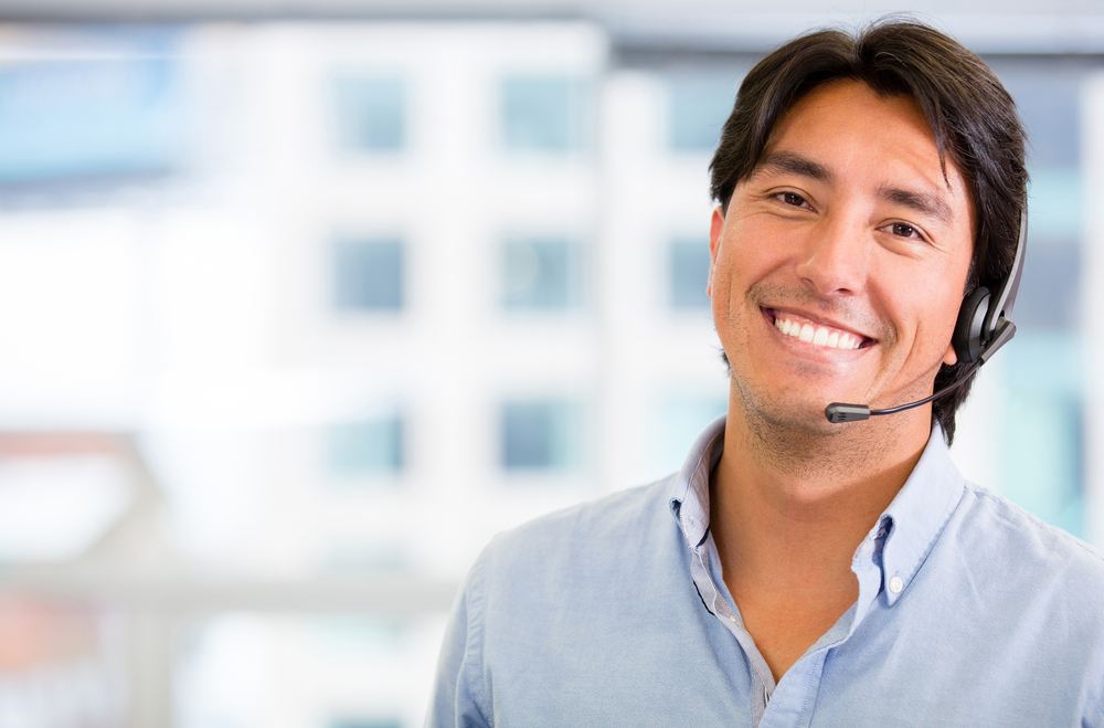 A smiling man wearing a headset