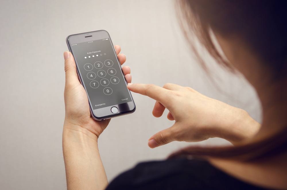 A young woman unlocking her phone