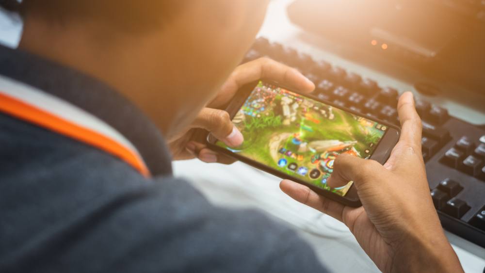 A young boy playing a game on his phone