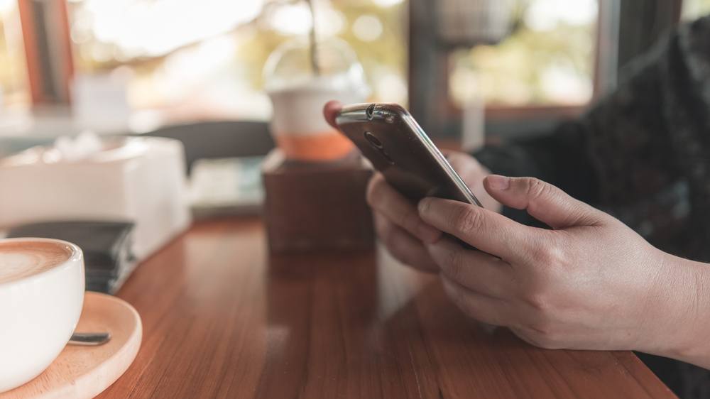 A man sitting at a table using his smartphone