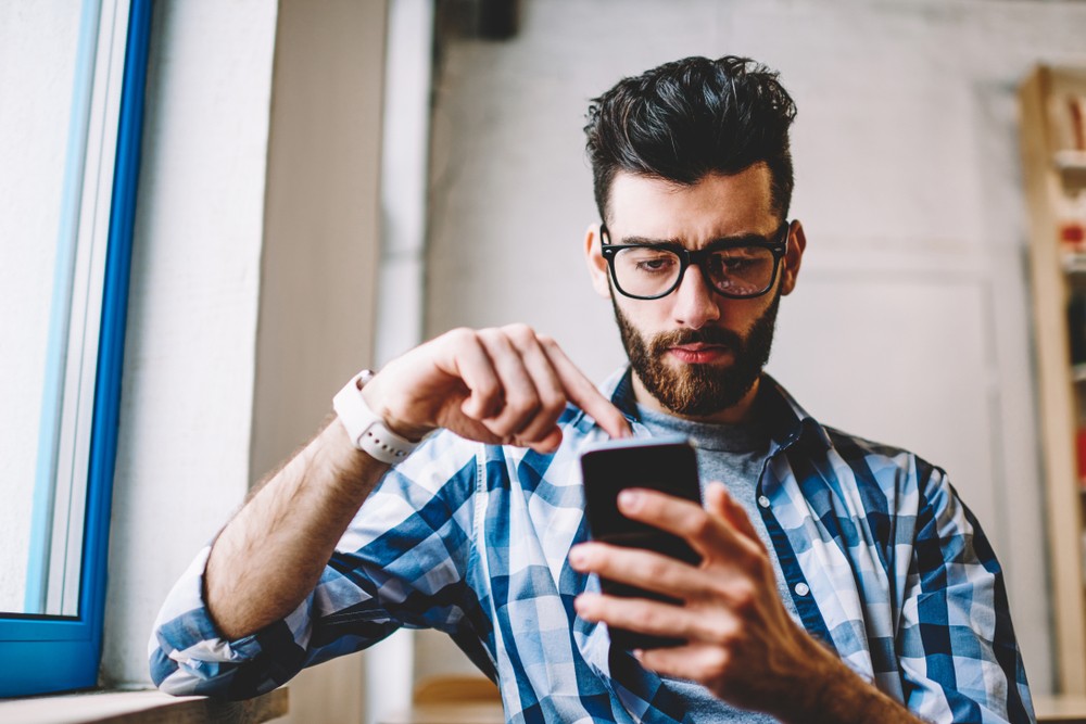 Young Man Concentrating And Using His App