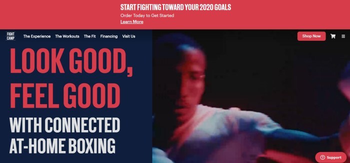 This screenshot of the home page for Fightcamp has a red header above a split main section, with red text over a black background on the left side of the page inviting visitors to look good and feel good through boxing, as well as a photo of a man boxing on the right side of the page.