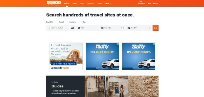 This screenshot of the home page for Kayak has an orange navigation bar above a white background with black text and black and gray search options, as well as two rows of smaller images with travel company advertisements, including a travel agency and car rentals, and a photo of a woman staring at some plates on a plastered wall in a narrow street.