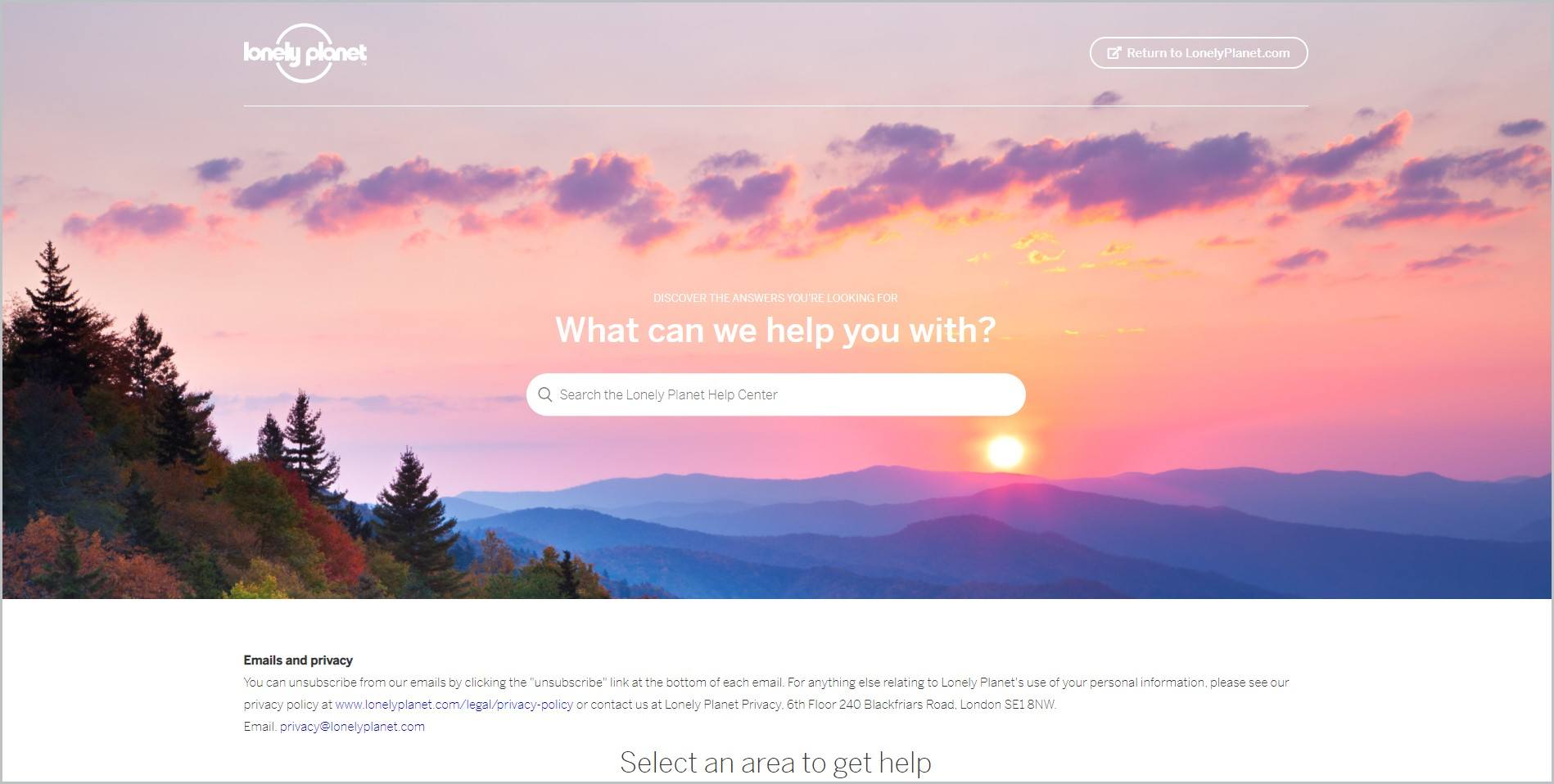 screenshot of Lonely Planet homepage featuring an image of the sky with clouds and the sun rising above the mountain ranges