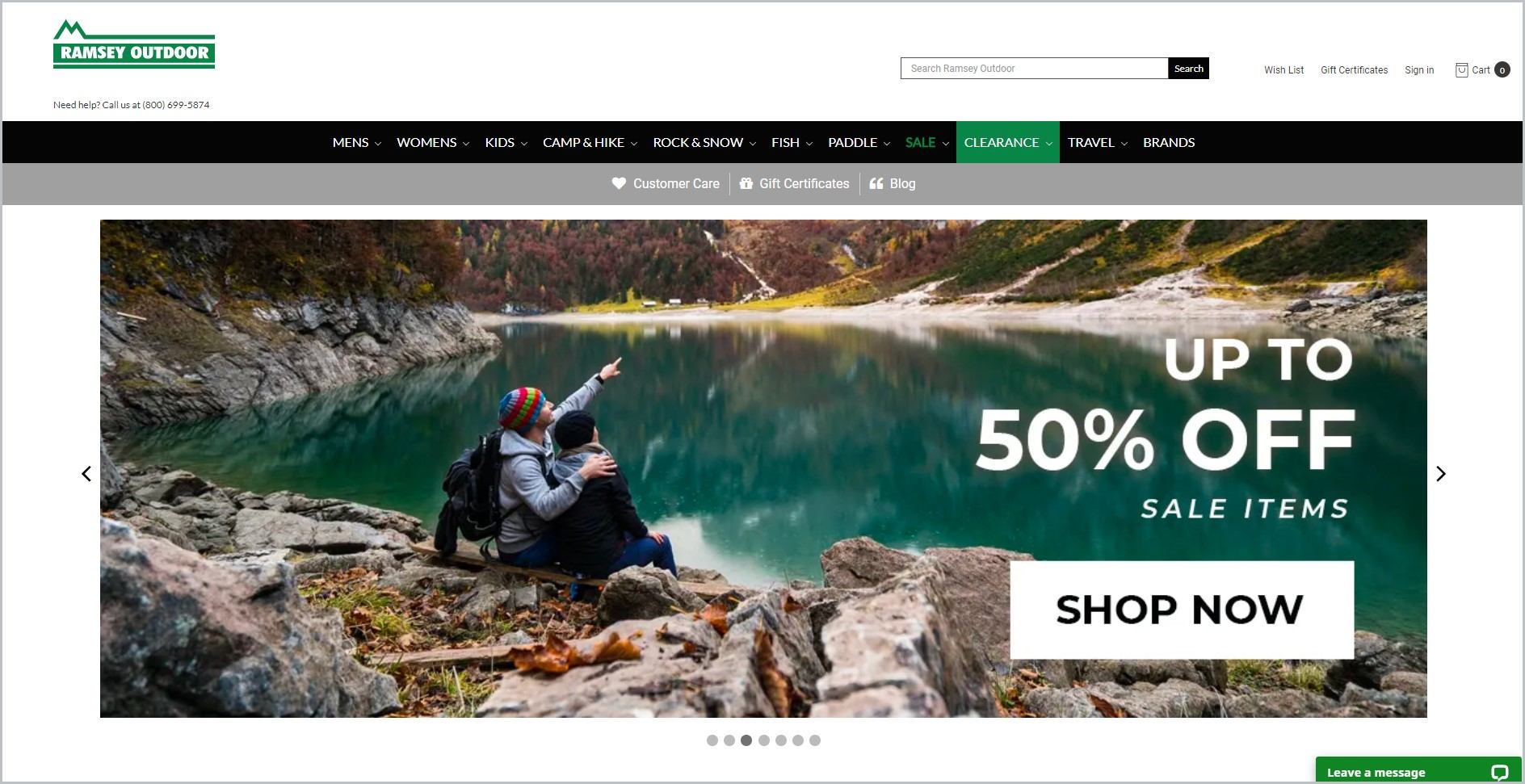 screenshot of Ramsey Outdoor homepage, with white header bearing the website's name and search bar, underneath it is the black main navigation bar, it showcases a picture of a couple looking over a lake outdoors