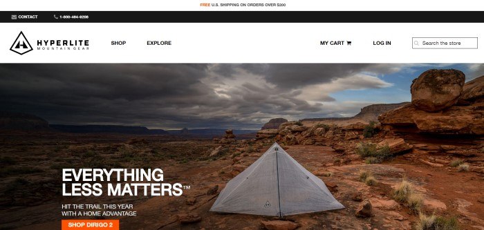 This screenshot of the home page for Hyperlite Mountain Gear has a white and black header, a white navigation bar, and a large photo of a tent pitched in a desert as a storm approaches, next to white text that reads 'Everything less matters' and an orange call-to-action button.