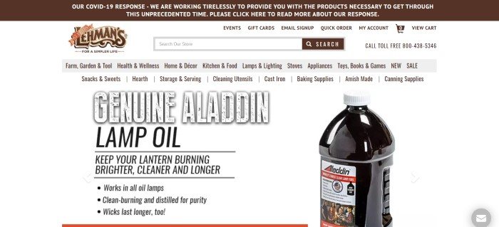 This screenshot of the home page for Lehman's has a brown header with white lettering discussing COVID-19's impacts on shipping, above a white search bar and menu, which is above a gray secondary menu and a photo of a bottle of Aladdin lamp oil on a white background, next to text in black describing the lamp oil.