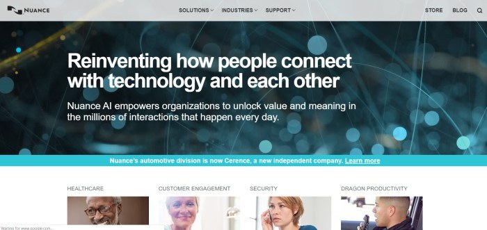 This screenshot of the home page for Nuance has a gray navigation bar above an out-of-focus photo of what appears to be blue and gold wires, behind white text describing Nuance AI as a way to reinvent how people connect, above a row of photos showing smiling people along with text indicating different segments of the Nuance company.