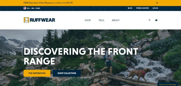 This screenshot of the home page for Ruffwear has an orange and black header with an announcement for free shipping, a white navigation bar, and a large photo of a man hiking with his dog on a bridge going over a mountain stream, along with white text inviting visitors to discover the front range and two call-to-action buttons.