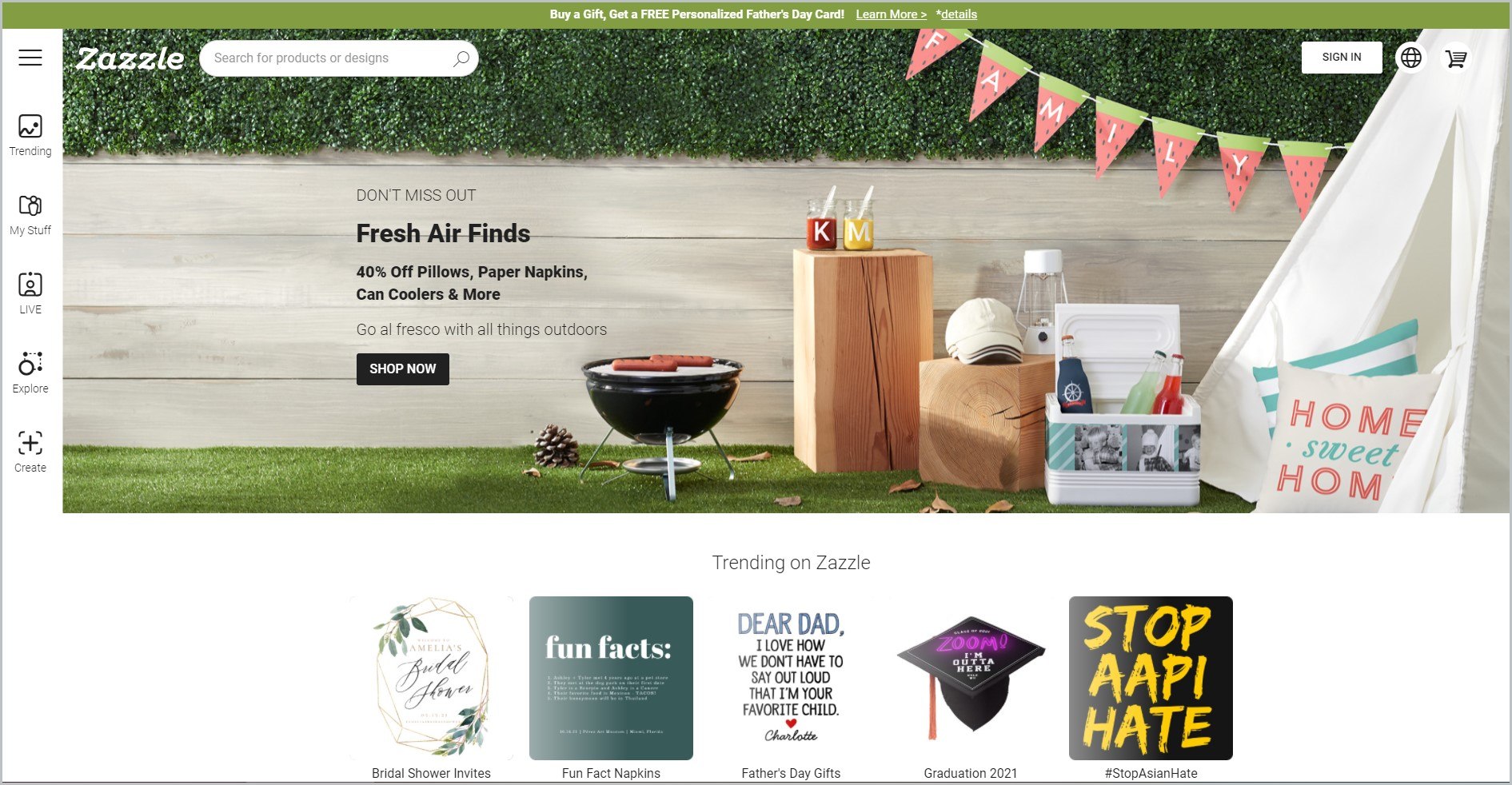 screenshot of Zazzle homepage with lime green announcement bar, and an image of a backyard picnic setup