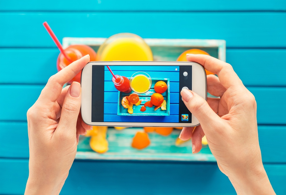 blogger taking colorful photograph for instagram using a smarthpone