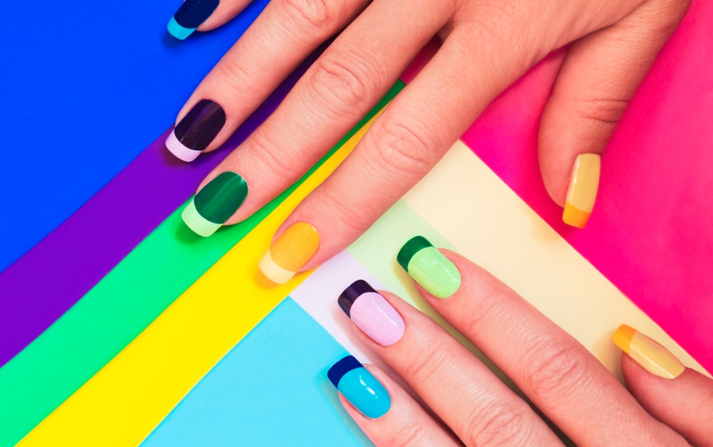 brightly colored fingernails on neon color variated background