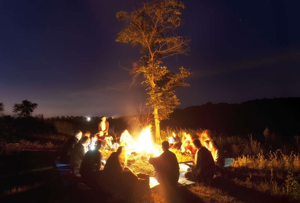 christian youth sitting around a camp fire