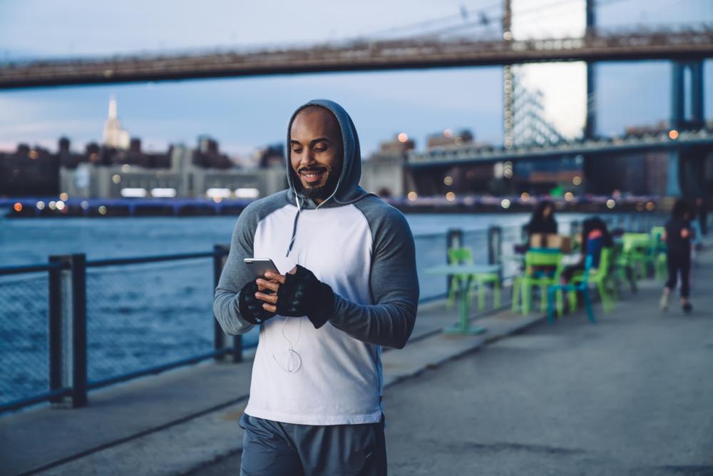 fitness blogger engaging with fans on his smartphone with social media