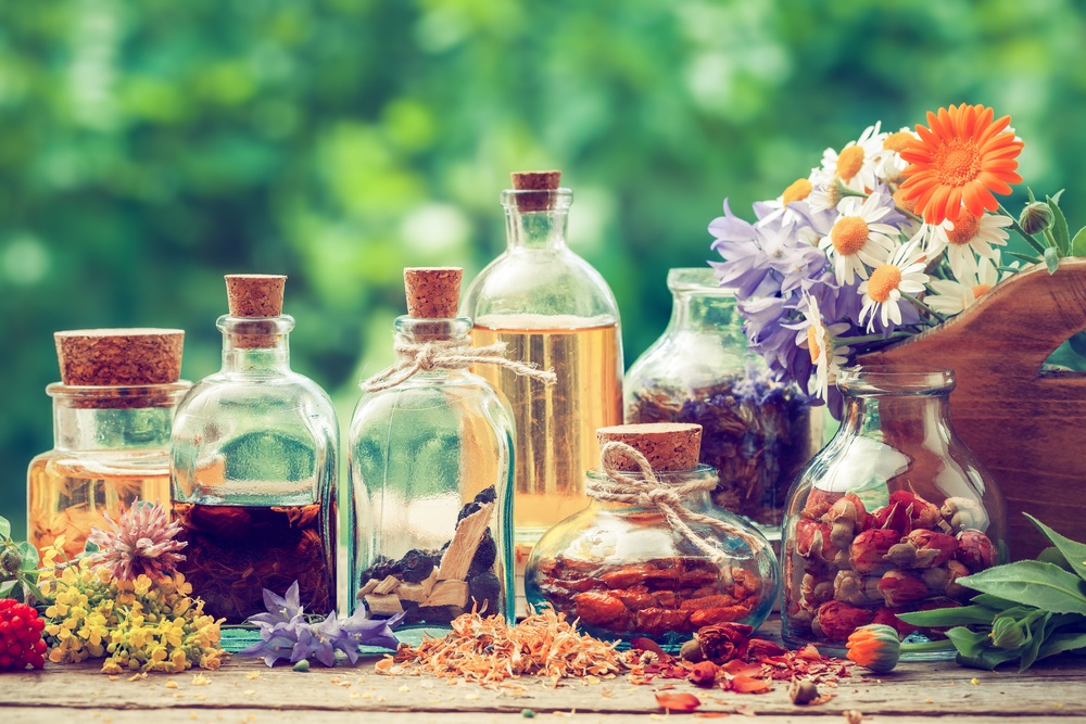 hazy filter image of antique essential oil bottles with flowers