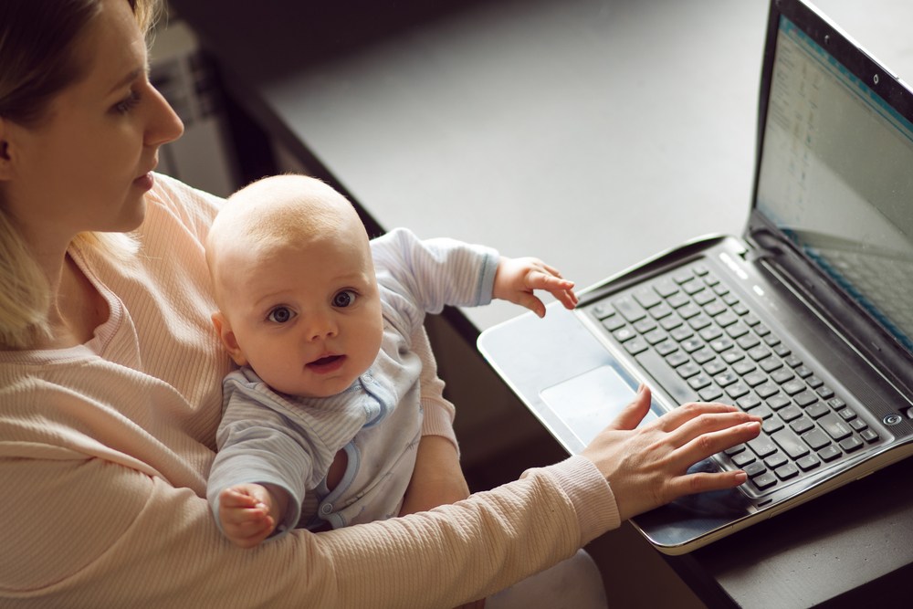 new mom starting a blog on a laptop with a baby in her lap