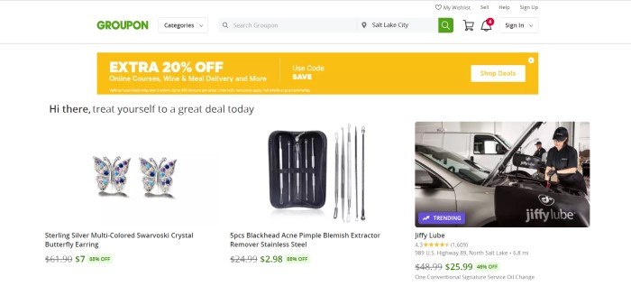 This screenshot of the home page for Groupon has a white header and background, a yellow sales bar, and a row of products for sale, including butterfly earrings, hygiene products, and an oil change.