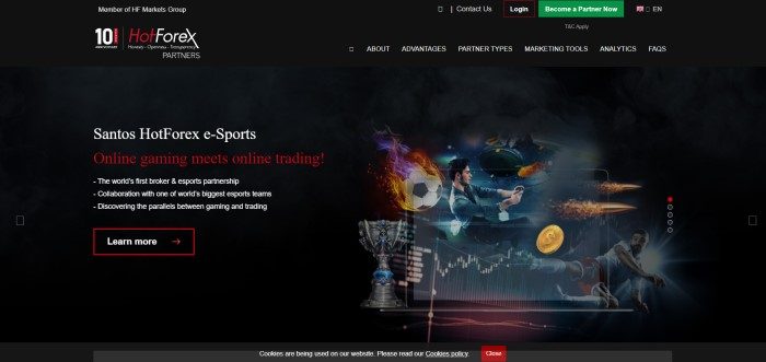 This screenshot of the home page for HotForex has a black header and navigation bar, a black background, a dark filtered photo showing a man with dark hair playing esports soccer, and white and red text announcing HotForex e-sports, along with a red and white call to action button.