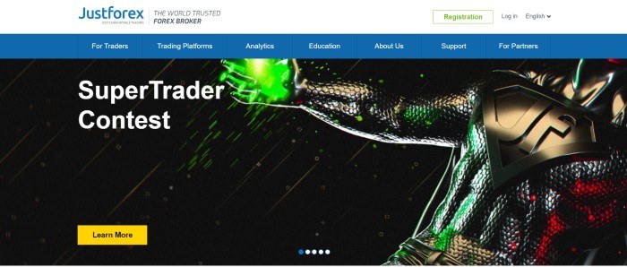 This screenshot of the home page for JustForex has a white header, a blue navigation page, and a dark photo of what looks like a superhero in dark clothes with green light in his hands, next to white text that reads 'Supertrader Contest'and a yellow call to action button.