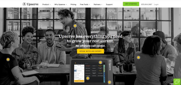 This screenshot of the home page for Upserve has a white header and navigation bar with a green call to action button above a black and white photo of the inside of a restaurant, with a table of three people talking to a smiling waiter with pen and pad in hand, as well as several other tables of happy people, along with white text and a yellow call to action button.