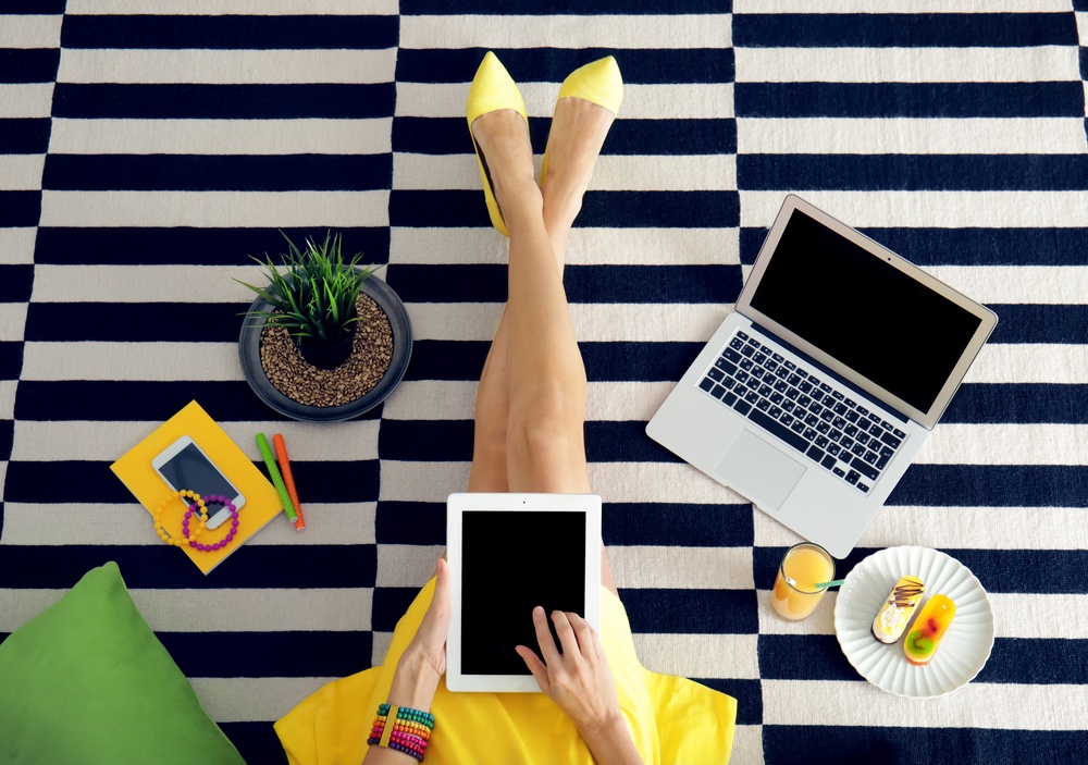 woman searching on fashion blog with yellow dress and multiple internet connected devices