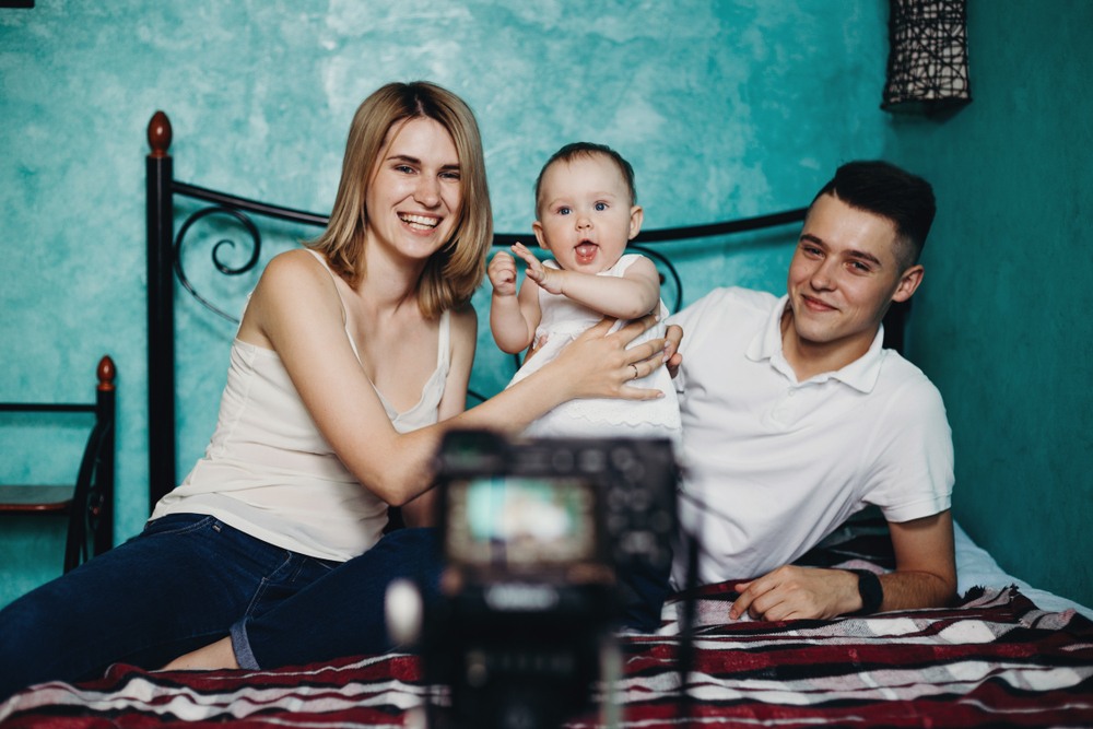 young family taking selfie with DSLR camera to post as author bio on family blog