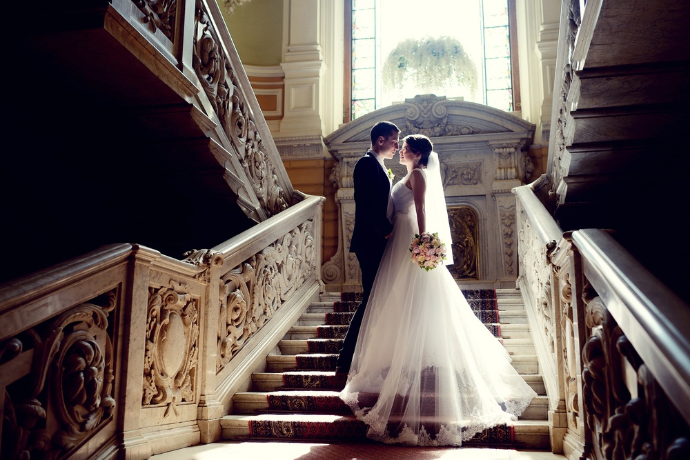 bride and groom standing on steps looking into each other's eyes