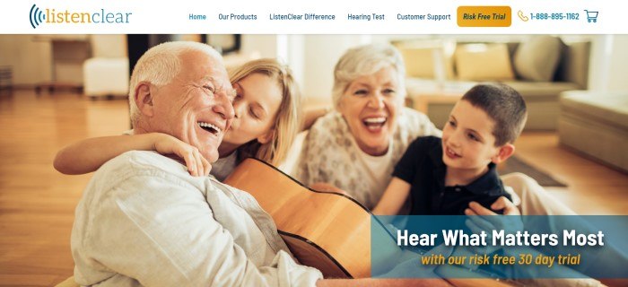 This screenshot of the home page for ListenClear has a white navigation bar with an orange call to action button above a photo of an elderly gentleman with a guitar being hugged by a young blonde girl, while a white-haired woman and a young dark-haired boy smile at them, along with white and orange text.