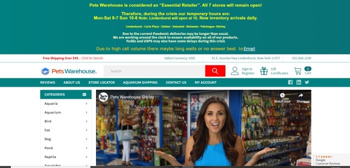 This screenshot of the home page for Pets Warehouse has a wide teal header with yellow text above a white search bar, a teal navigation bar, and a main section with a white background, a category menu on the left side of the page, and a still shot of a video showing a smiling dark-haired woman in a blue shirt standing inside a pet supply store.