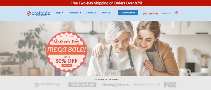 This screenshot of the home page for Otofonix has a red header, a light blue navigation bar, and a large photo of a young woman with brown hair hugging a white-haired woman in a white shirt and a gray apron, along with a red and beige round sales announcement above a gray bar with darker gray words showing media outlets.