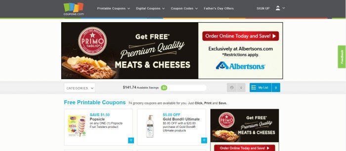 This screenshot of the home page for Coupons.com has a charcoal navigation bar, a white background, a black ad section featuring meat and cheese on a cutting board, a beige ad section on the right side of the page with a red call to action button, and a few small coupon product images across the bottom of the page.