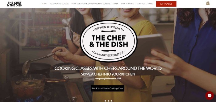 screenshot of the home page for The Chef And The Dish j This screenshot of the home page for The Chef And The Dish has a white navigation bar with a red tab for gift cards above a photo of three smiling women looking at a tablet while cooking, along with white and black text inviting people to try at-home cooking classes, and a black call to action button.