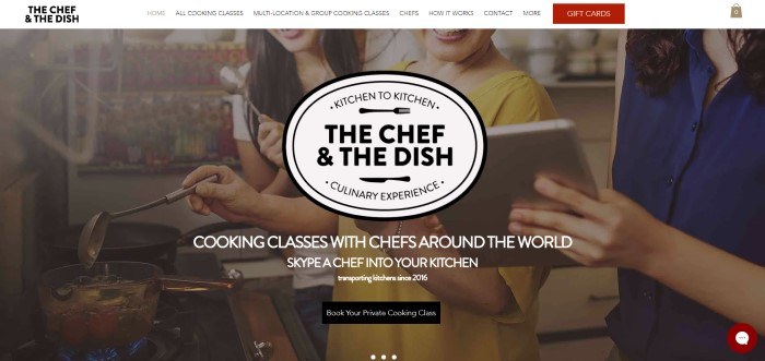 This screenshot of the home page for The Chef And The Dish has a white navigation bar with a red tab for gift cards above a photo of three smiling women looking at a tablet while cooking, along with white and black text inviting people to try at-home cooking classes, and a black call to action button.