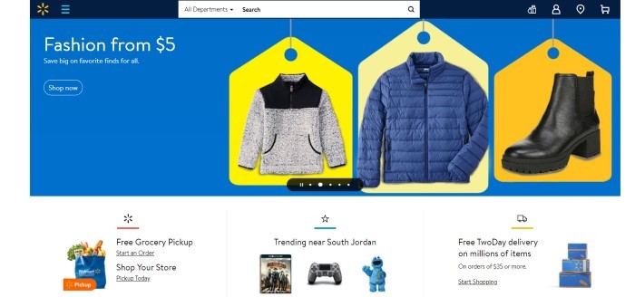 This screenshot of the home page for Walmart has a dark blue header with a search bar and a royal blue main section with bright yellow price tags behind various jackets in black, white, and blue, along with white text announcing fashions on sale.