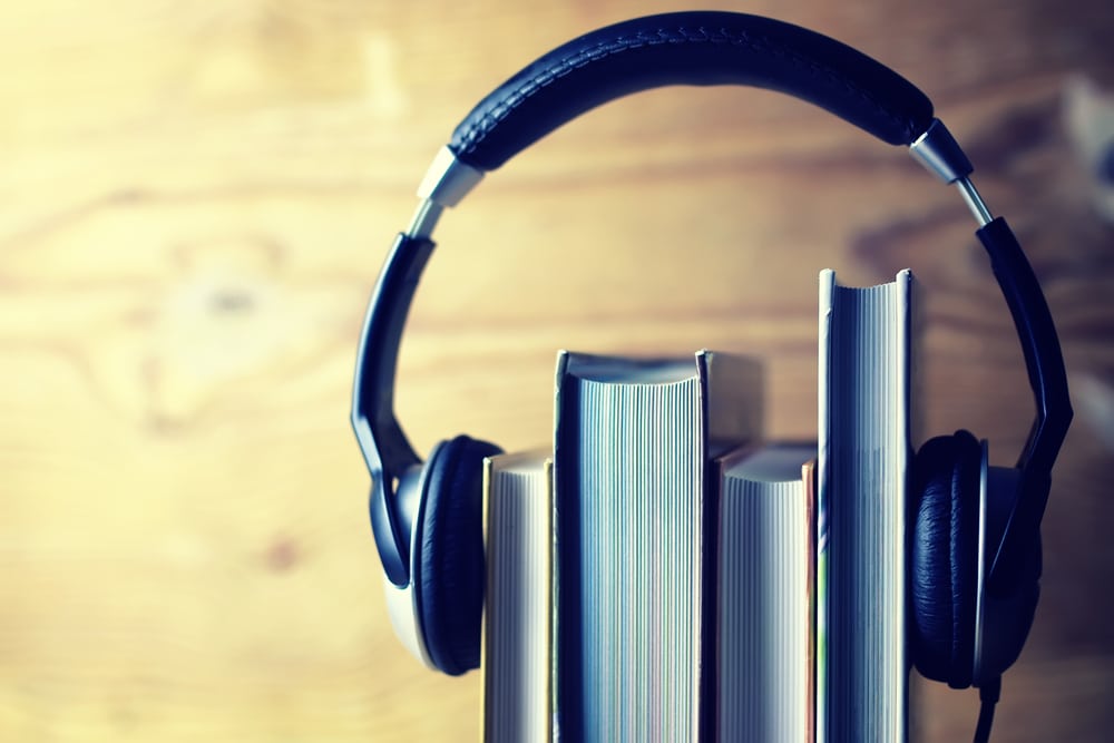 large headphones around stack of books