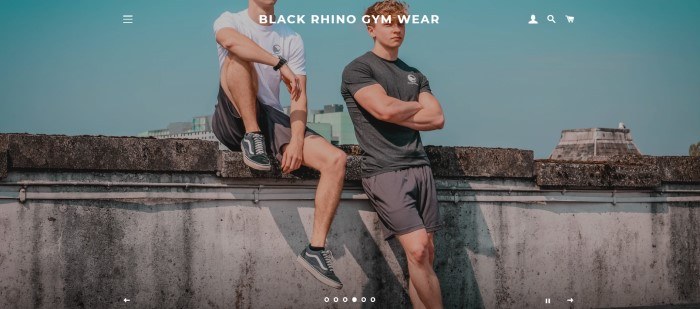 This screenshot of the home page for Black Rhino shows two young men in gray and white exercise clothing near a concrete wall in front of a cityscape, behind white lettering announcing Black Rhino gym wear.