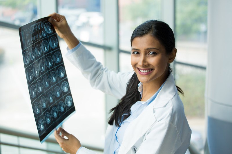 female radiologist looking at a ct scan