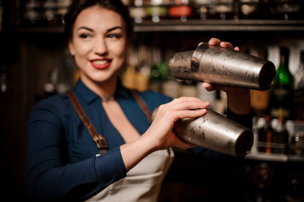 female bartender with red lipstick and two shakers