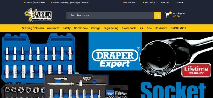 This screenshot of the home page for Everyday Welding Supplies has a black header, search bar, and main background with a yellow navigation bar and a photo of tools in a blue tool box near the bottom of the page.