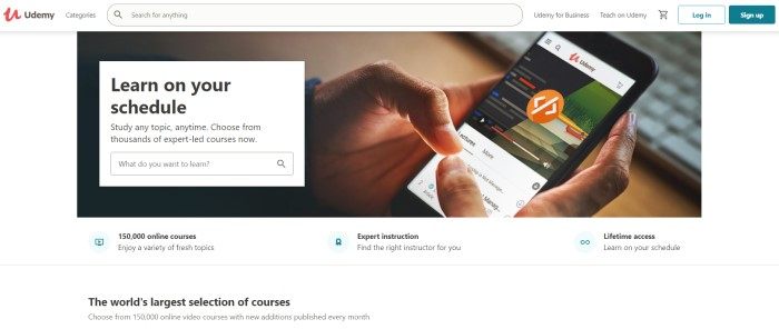 This screenshot of the home page for Udemy has a white search bar and background and a large photo of a man's hands using the Udemy app on a mobile device, as well as a white search section with black text, and black text below the photo describing different features of this platform.