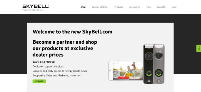 This screenshot of the home page for SkyBell has a white navigation bar with black text above a black and white main section with black text and a green call to action button on a white background section on the left side of the page and a photo of a mobile device with someone waving from the front porch next to two doorbell cameras.