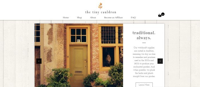 This screenshot of the home page for The Tiny Cauldron has a background of white painted wood behind a weathered storefront with pink bricks, a yellow door, and yellow trim around the windows, along with a white text section with black text on the right side of the page.