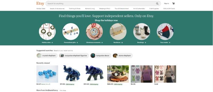 This screenshot of the home page for Etsy has a white navigation bar and search bar above a green announcement section with a row of categories with circular images showing types of products to shop for, above a white main section with photos showing product images for suggested searches and recently searched items.